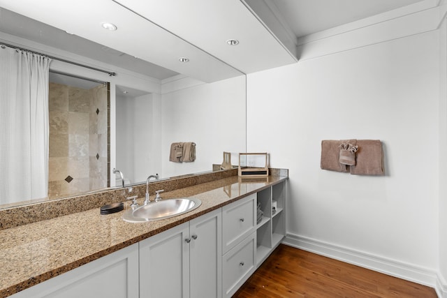 bathroom featuring hardwood / wood-style floors, oversized vanity, and a tile shower