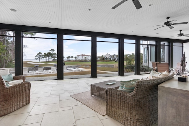 living room with a wall of windows, a wealth of natural light, ceiling fan, and light tile flooring