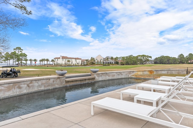 exterior space featuring a patio area, a lawn, and a water view