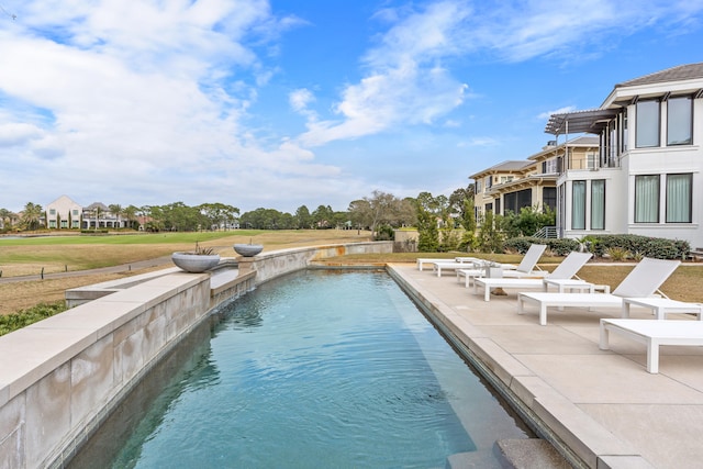 view of pool with a patio area and a yard