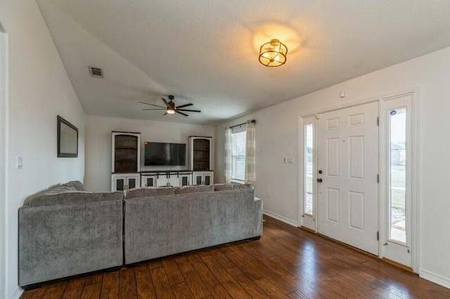 unfurnished living room with dark hardwood / wood-style floors, ceiling fan, and vaulted ceiling