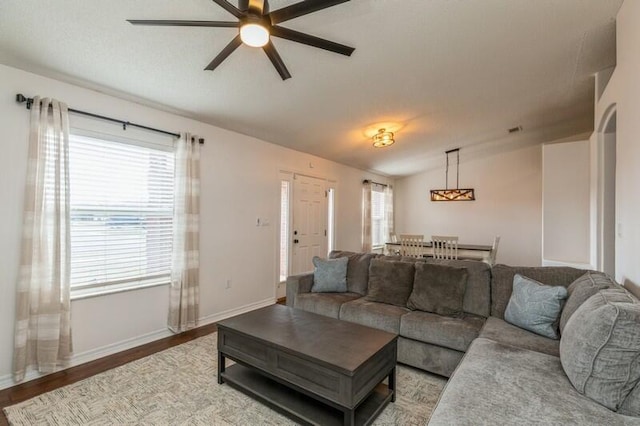 living room with hardwood / wood-style floors, ceiling fan, and vaulted ceiling