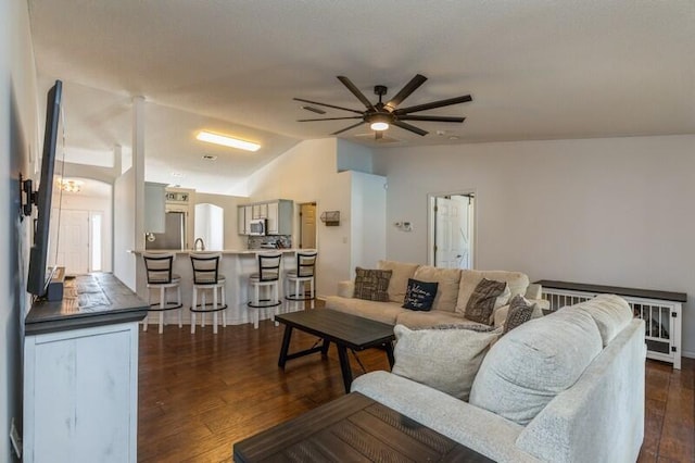 living room featuring ceiling fan, dark wood-type flooring, and lofted ceiling