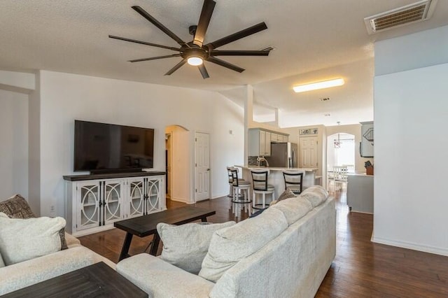 living room with wood-type flooring, ceiling fan, and lofted ceiling