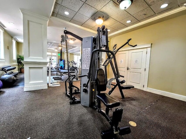 workout area with decorative columns, crown molding, and carpet flooring