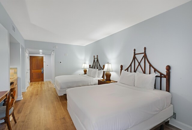 bedroom featuring light hardwood / wood-style flooring and ensuite bathroom