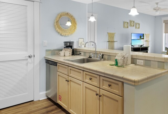 kitchen featuring hardwood / wood-style floors, sink, kitchen peninsula, hanging light fixtures, and dishwasher