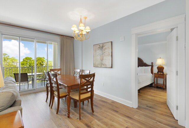 dining space with light hardwood / wood-style flooring and an inviting chandelier