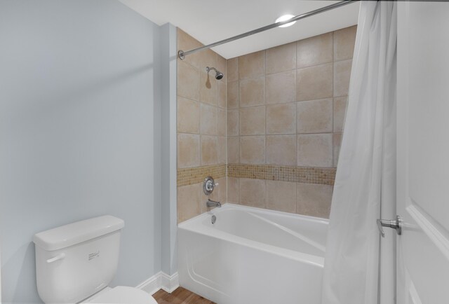 bathroom with wood-type flooring, toilet, and shower / tub combo with curtain