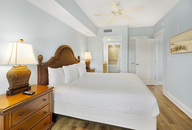 bedroom with connected bathroom, hardwood / wood-style flooring, and ceiling fan