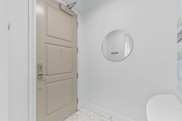 bathroom with ornamental molding, toilet, and tile flooring