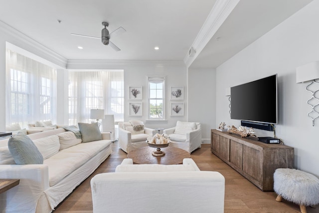 living room featuring hardwood / wood-style flooring, ornamental molding, and ceiling fan