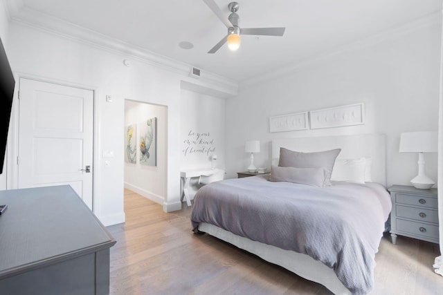 bedroom featuring crown molding, light hardwood / wood-style flooring, and ceiling fan