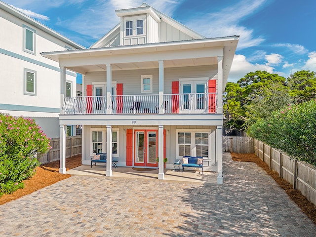 rear view of house featuring a patio area, french doors, and a balcony