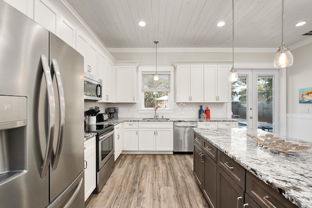 kitchen featuring plenty of natural light, light hardwood / wood-style flooring, stainless steel appliances, and decorative light fixtures