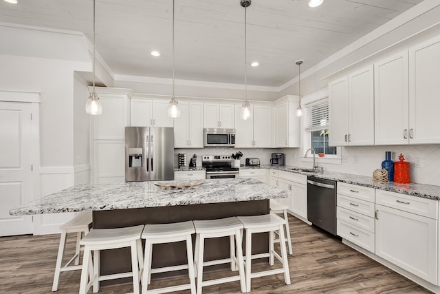 kitchen with sink, tasteful backsplash, dark wood-type flooring, stainless steel appliances, and pendant lighting