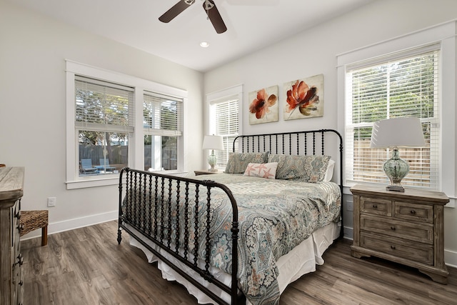 bedroom with dark hardwood / wood-style flooring, ceiling fan, and multiple windows