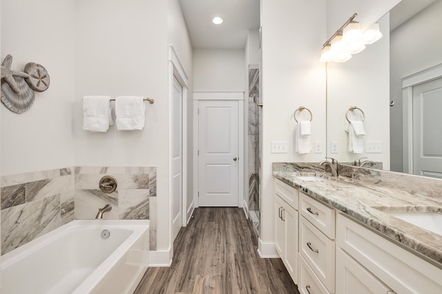 bathroom featuring dual vanity, a bathtub, and hardwood / wood-style floors