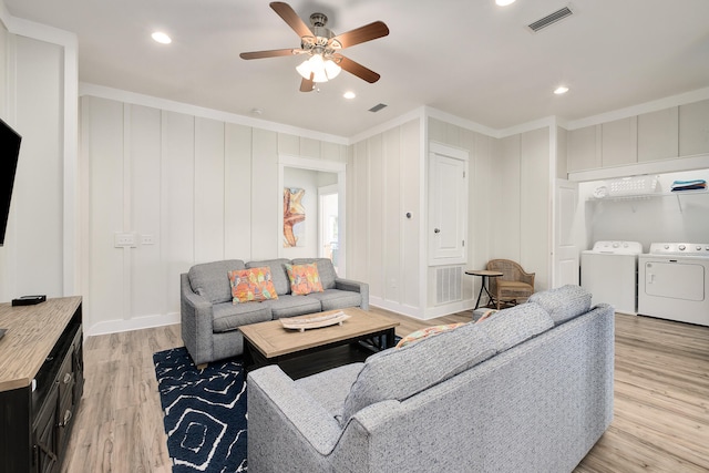 living room featuring ornamental molding, ceiling fan, light wood-type flooring, and washing machine and clothes dryer