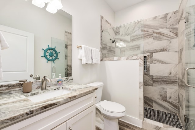 bathroom featuring walk in shower, vanity with extensive cabinet space, and toilet