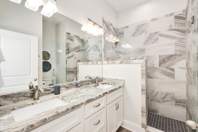 bathroom with dual vanity and a shower with shower door