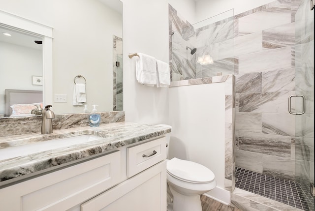 bathroom with wood-type flooring, a shower with door, vanity, and toilet