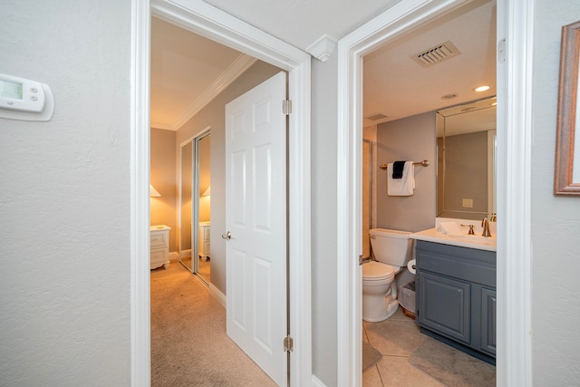 hall with ornamental molding, visible vents, a sink, and light tile patterned floors