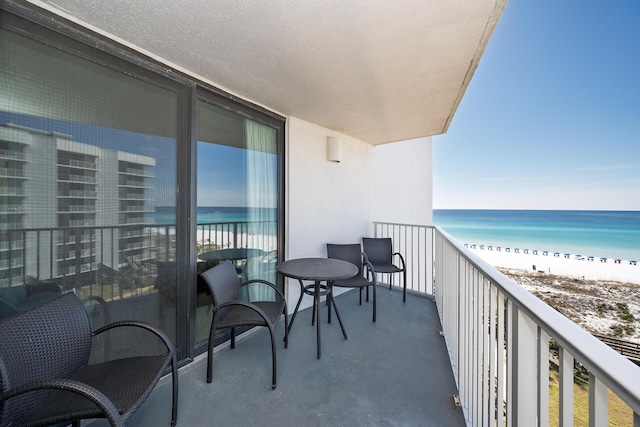 balcony featuring a water view and a beach view