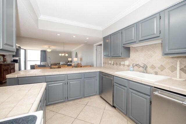 kitchen featuring ornamental molding, a peninsula, stainless steel dishwasher, and a sink