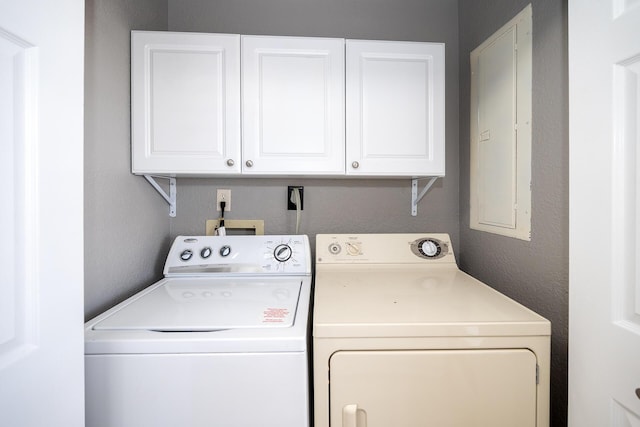 laundry area with a textured wall, cabinet space, and independent washer and dryer