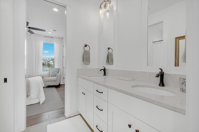 bathroom with dual bowl vanity, ceiling fan, and wood-type flooring