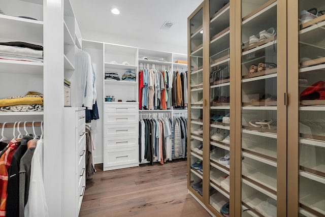 walk in closet with hardwood / wood-style floors