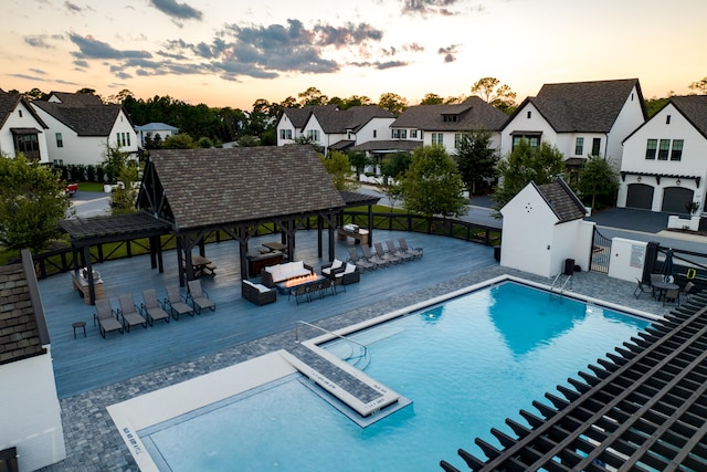 pool at dusk with a gazebo and a patio