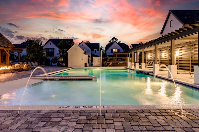 pool at dusk featuring a patio