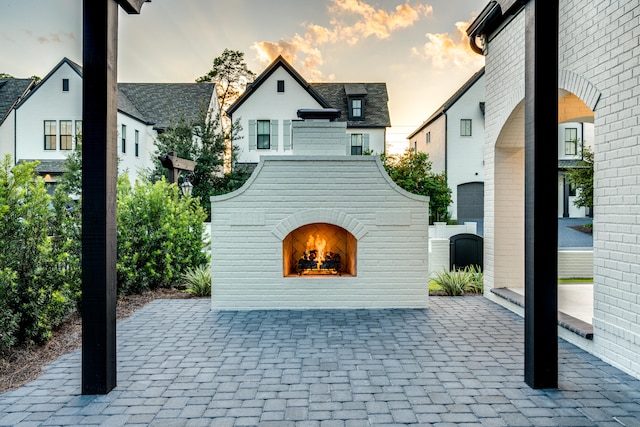 patio terrace at dusk with an outdoor fireplace