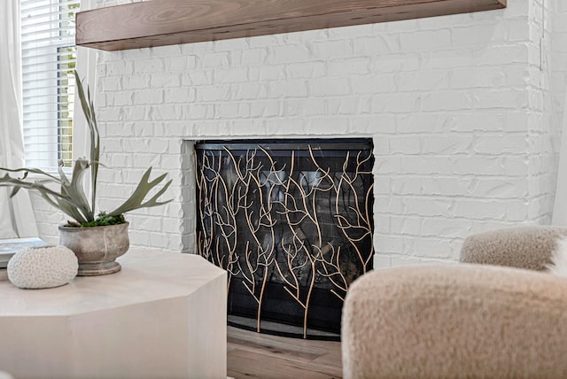 room details with wood-type flooring and a brick fireplace