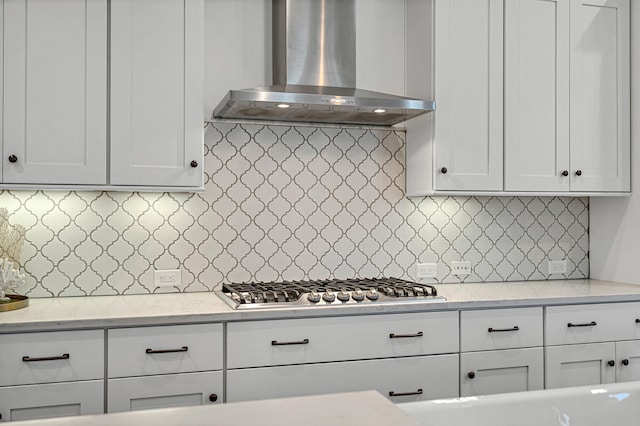 kitchen featuring backsplash, white cabinets, and wall chimney exhaust hood