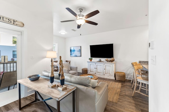 living room featuring dark wood-type flooring and ceiling fan