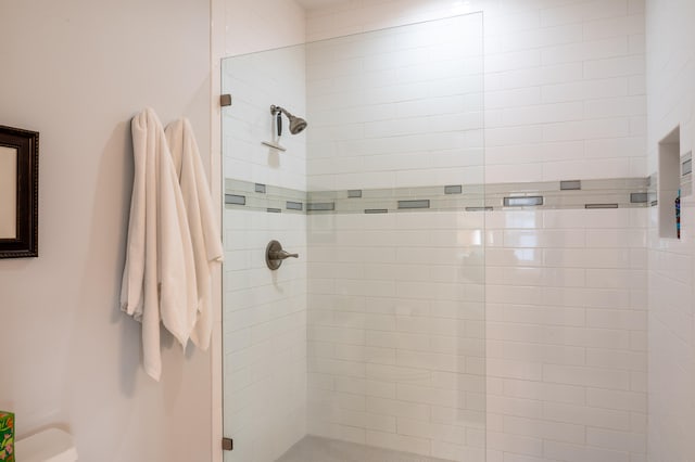 bathroom featuring walk in shower and toilet