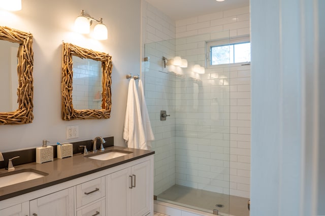 bathroom with a shower with shower door and double vanity