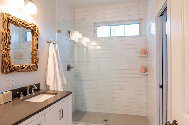 bathroom featuring tiled shower and vanity