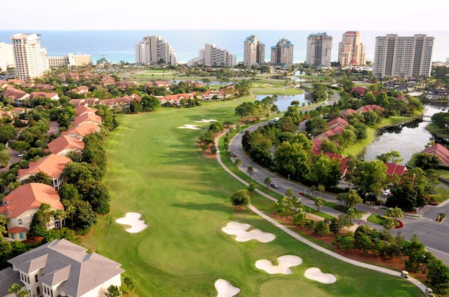 bird's eye view with a water view, view of golf course, and a city view