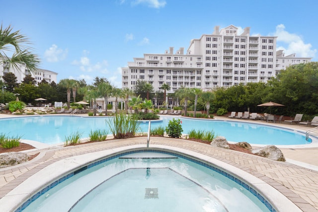 pool with a patio area and a community hot tub