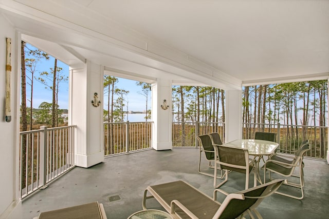 sunroom featuring a water view