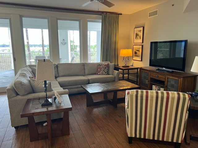 living room with visible vents, dark wood finished floors, and ceiling fan