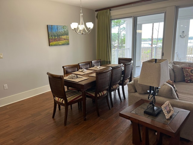 dining room featuring a notable chandelier, dark wood finished floors, and baseboards