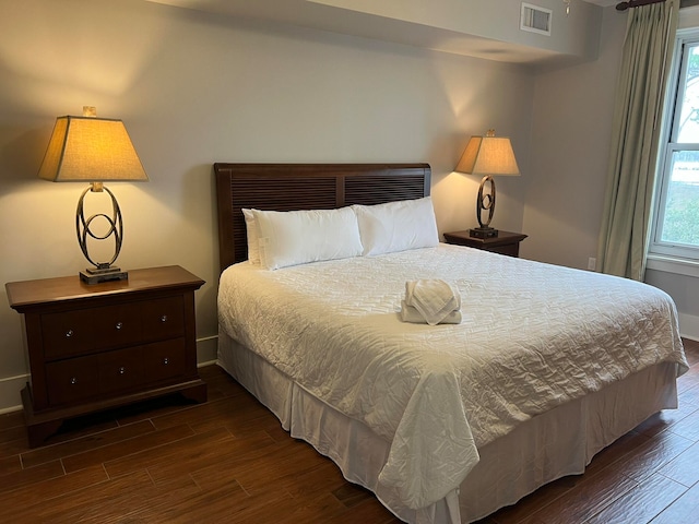 bedroom featuring multiple windows, wood finished floors, and visible vents