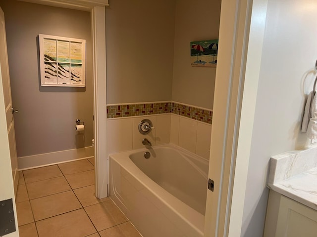 bathroom featuring a garden tub, toilet, vanity, baseboards, and tile patterned floors