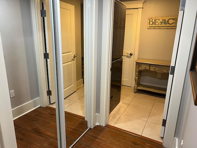 corridor featuring baseboards and wood finished floors