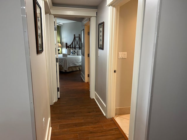 corridor featuring baseboards and wood finished floors